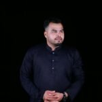 A confident man in traditional Bangladeshi attire against a dark studio backdrop.